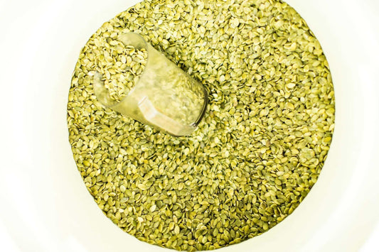 A bin of organic pumpkin seeds, ready to be mixed into a batch of Michele's Granola