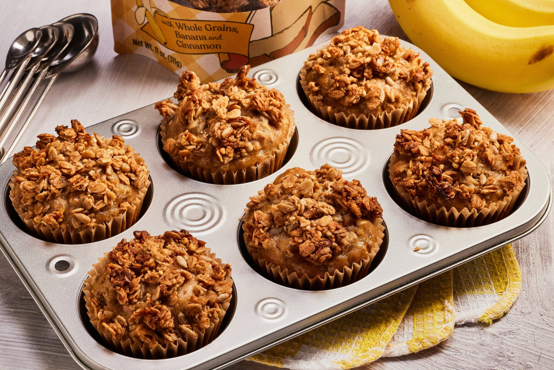 A muffin tin of freshly baked Double Banana Bread Muffins, topped with granola