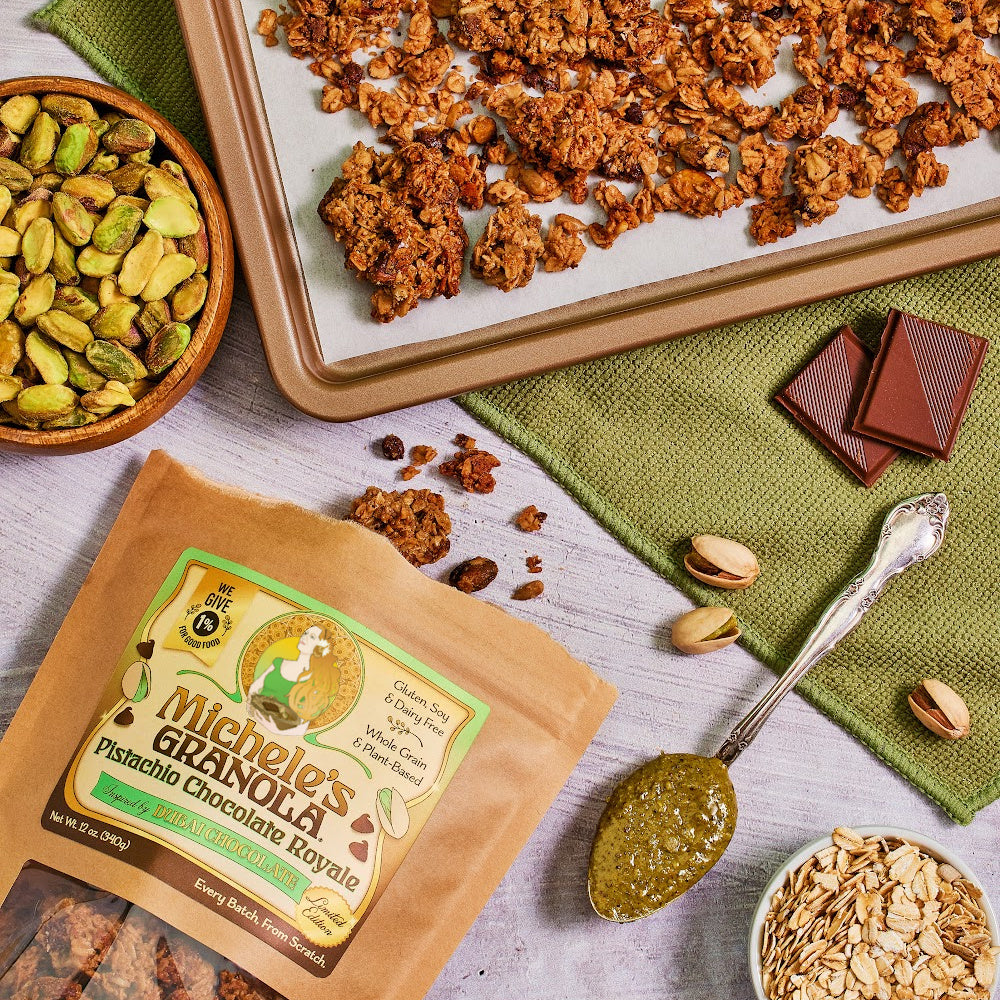 Michele's Pistachio Chocolate Royale Granola 12oz bag with sheet pan of granola and bowls of ingredients including pistachios, oats, and chocolate