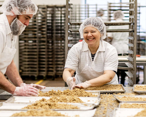 Smiling employee, making a new batch of granola.